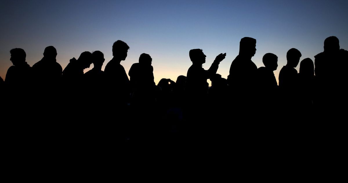 Мигранты и беженцы стоят в очереди за едой в импровизированном лагере на греко-македонской границе возле села Идоменей, Греция. / © Reuters