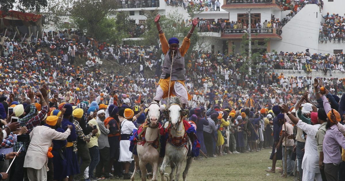 Ниханг, или воин-сикх, ездит на двух лошадях во время праздника Холла Мохалла в северном штате Пенджаб, Индия. Этот праздник отмечается во время другого праздника Холи и собирает сикхов со всей страны. / © Reuters