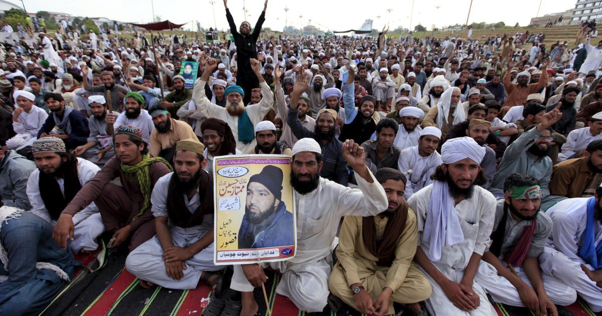 Мужчина держит фото с Мумтазом Кадри, полицейским, убившим губернатора одной из провинций Пакистана за богохульство и был за это казнен. Пакистанцы устроили сидячую акцию протеста против казни Кадри перед зданием парламента в Исламабаде. / © Reuters