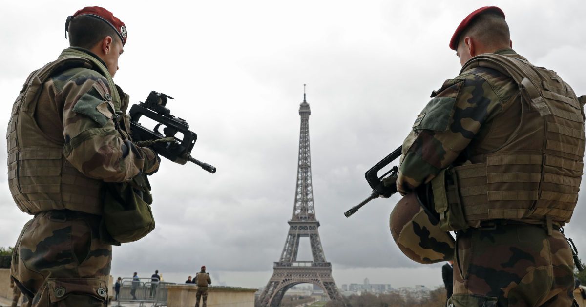 Патруль французской армии стоит рядом с Эйфелевой башней в Париже, Франция. Власти страны приняли решение развернуть 1600 дополнительных сотрудников полиции по укреплению безопасности на своих границах и на общественном транспорте после смертоносных взрывов в Брюсселе. / © Reuters