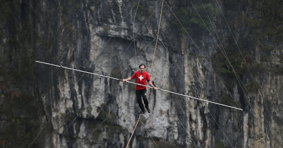 Канатоходец Фредди Нок из Швейцарии ходит по канату над пропастью во время соревнований в графстве Улун, Чунцин, Китай. / © Reuters