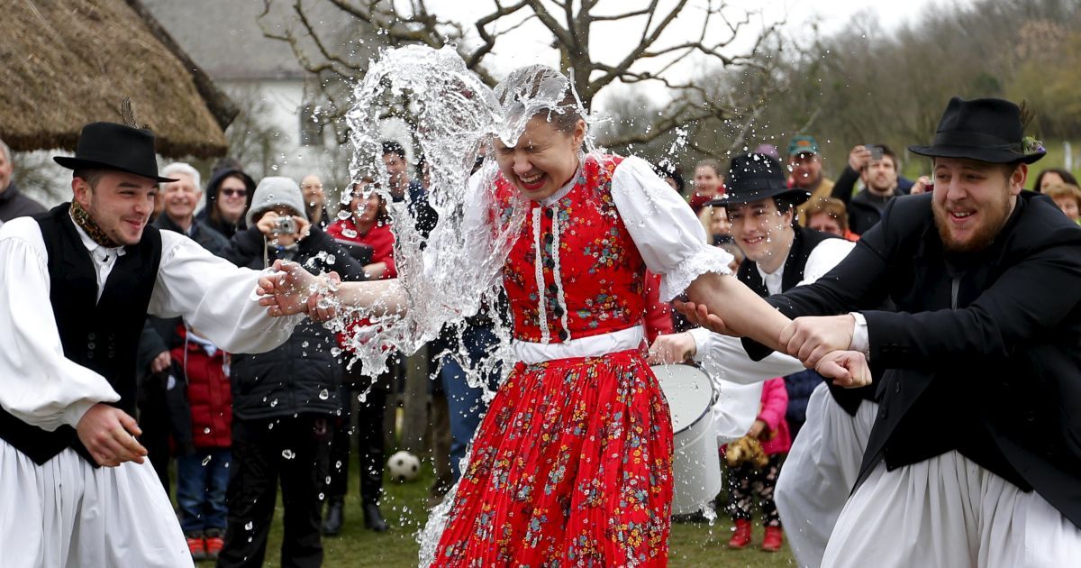 Мужчины льют воду на женщину во время празднования традиционных пасхальных праздников в Венгрии. / © Reuters
