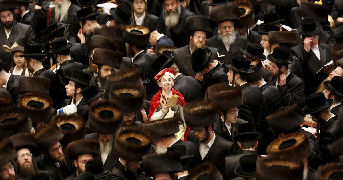 Ультраортодоксальный еврейский мальчик с хасидской династии Белз, одетый в красный костюм, участвует в чтении из книги Эсфирь во время еврейского праздника Пурим. Евреи отмечают этот праздник в память о спасении этого народа от геноцида в древней Персии. / © Reuters