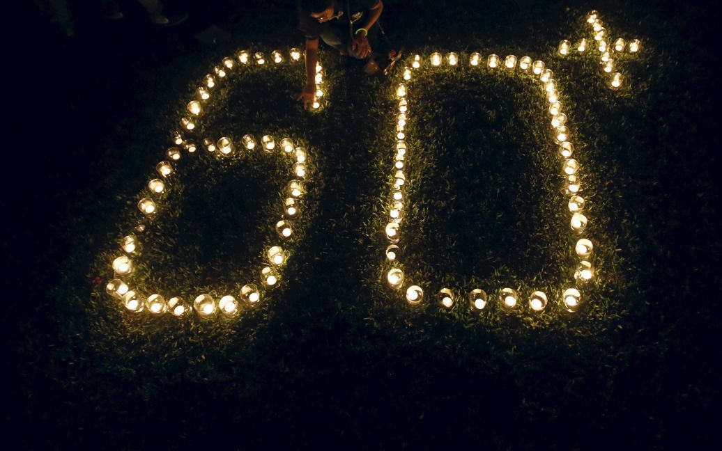 Жінка запалює лампи, щоб сформувати число 60, що представляє 60 хвилин Години Землі, під час акції Година Землі в Коломбо, Шрі-Ланка. / © Reuters