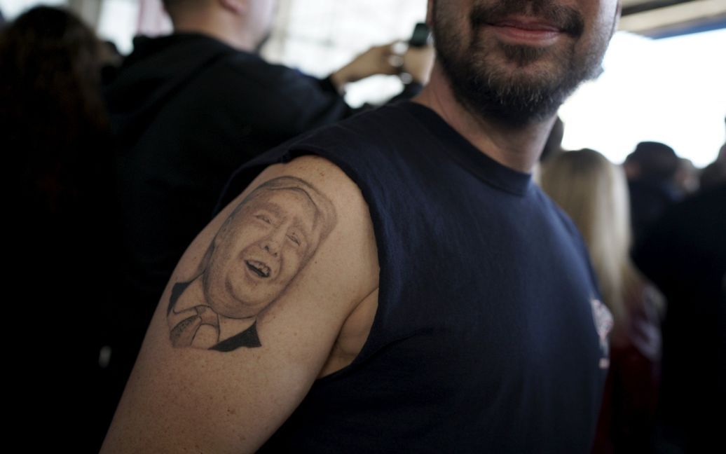 Мужчина показывает свою татуировку в виде кандидата в президенты США Дональда Трампа. / © Reuters