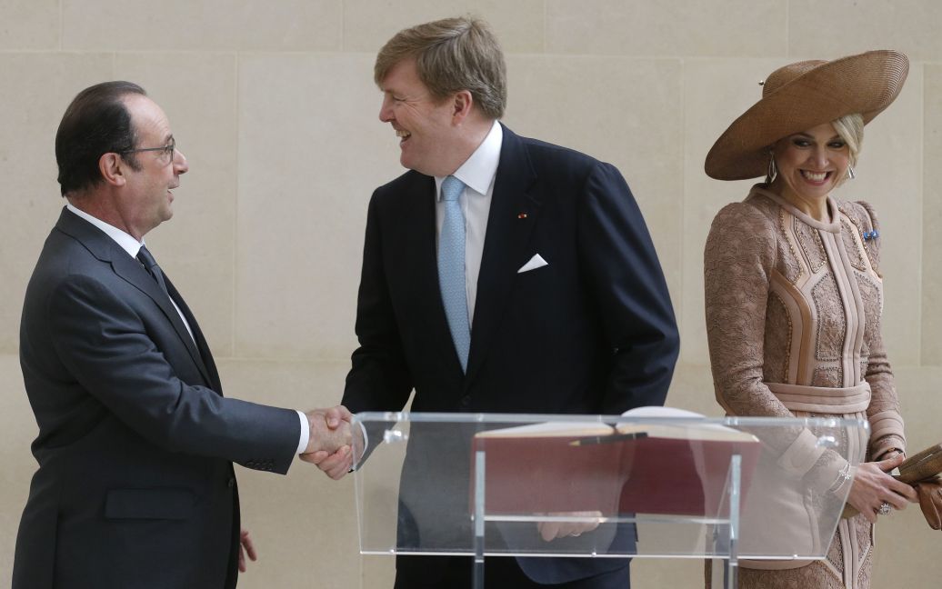 Президент Франції Франсуа Олланд потискує руку короля Нідерландів Віллема Олександра у той час, як поруч стоїть королева Максима. Голландські монархи перебувають у Франції з державним візитом. / © Reuters