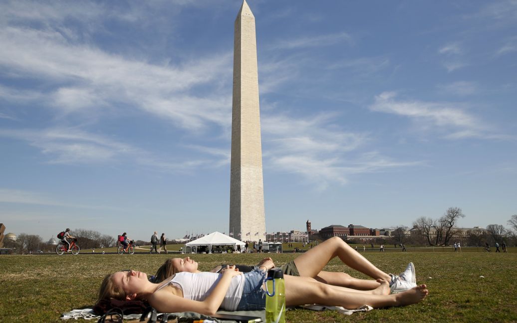 Студенты Университета Джорджа Вашингтона загорают возле памятника Вашингтону в несвоевременно теплый день в столице США. / © Reuters