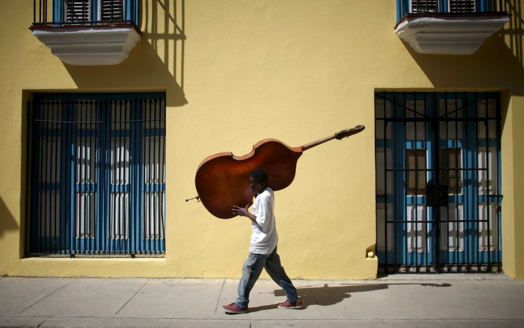 Музыкант несет контрабас в центре города Гавана, Куба. / © Reuters
