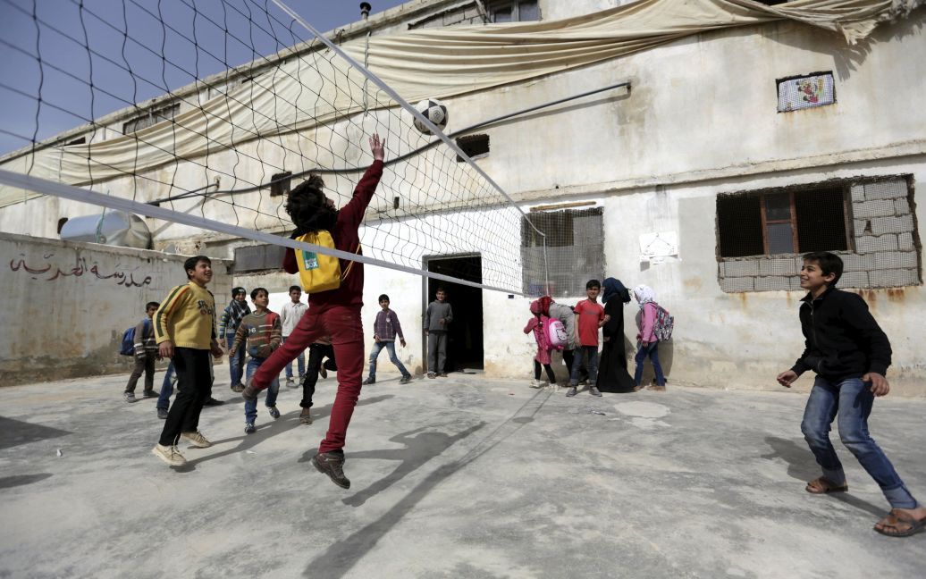 Ученики играют во время перерыва в школе в городе Аль-Альманах, в провинции Идлиб, Сирия. Жители города превратили бывшую птицеферму в школу более года назад. / © Reuters