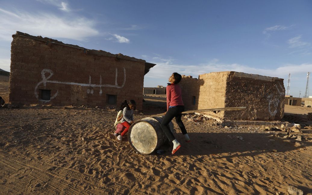 Девушки из коренного народа Западной Сахары сахрави играют на импровизированной качели в лагере беженцев в городе Тиндуф на юге Алжира. Генеральный секретарь ООН Пан Ги Мун планирует посетить сахарских беженцев в Алжире. / © Reuters