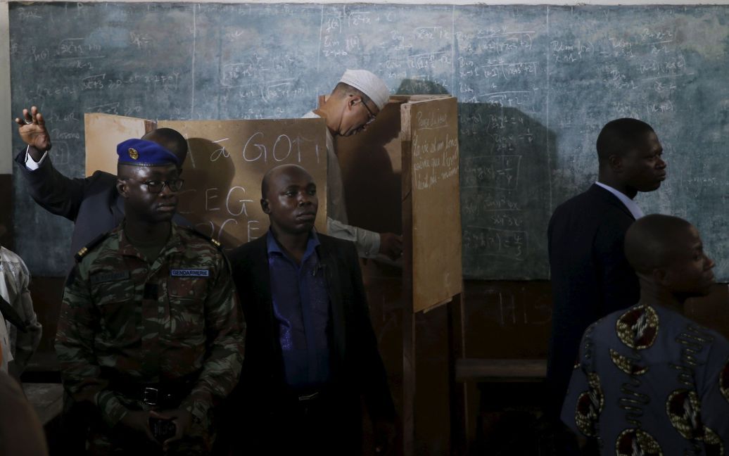 Лайонел Зенсу, премьер-министр Бенина и кандидат в президенты, охраняется сотрудниками службы безопасности в то время, как он готовится отдать свой голос во время президентских выборов на избирательном участке в Котону, Бенин. / © Reuters