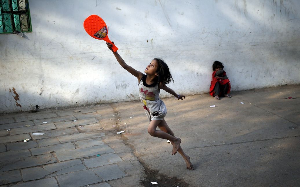 Ребенок играет с пластиковой ракеткой для бадминтона в старых кварталах Дели, Индия. / © Reuters