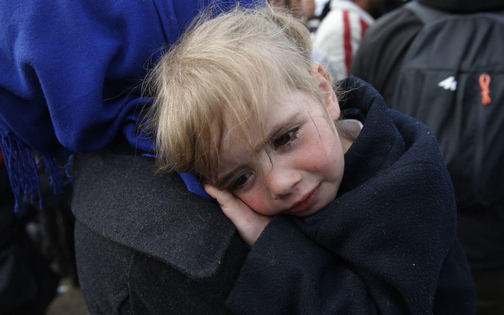 Ребенок мигрантов плачет во время ожидания пересечения греко-македонской границы, неподалеку от села Идоменей, Греция. / © Reuters