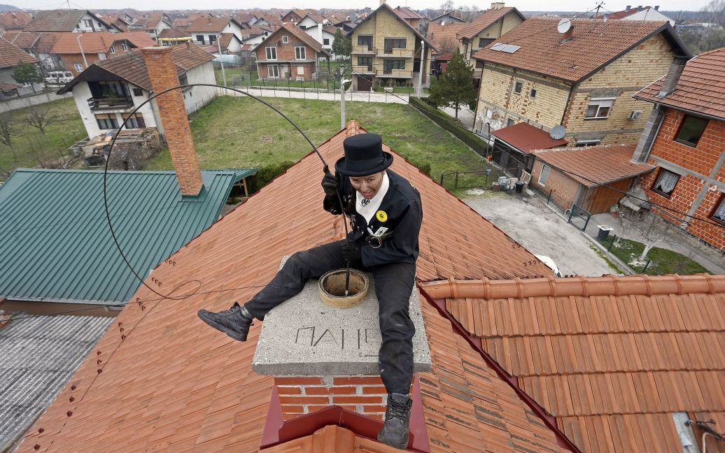 25-летний Дайана Джурич, который с шести лет работает трубочистом, очищает дымоход в городе Брчко, Босния и Герцеговина. / © Reuters