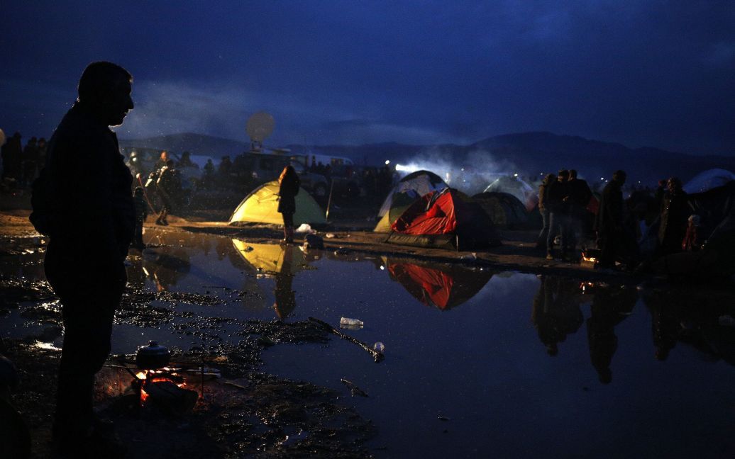 Мігрант стоїть в імпровізованому таборі у той час, як він чекає перетину греко-македонського кордону, недалеко від села Ідоменей, Греція. / © Reuters