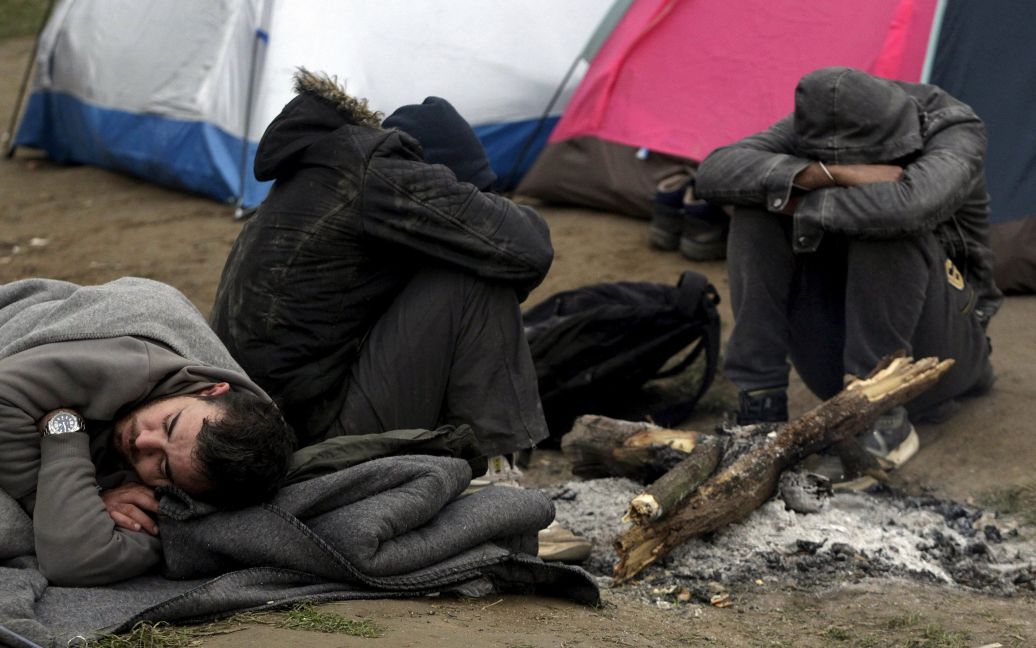 Люди разорвали колючую проволоку на заборе. / © Reuters