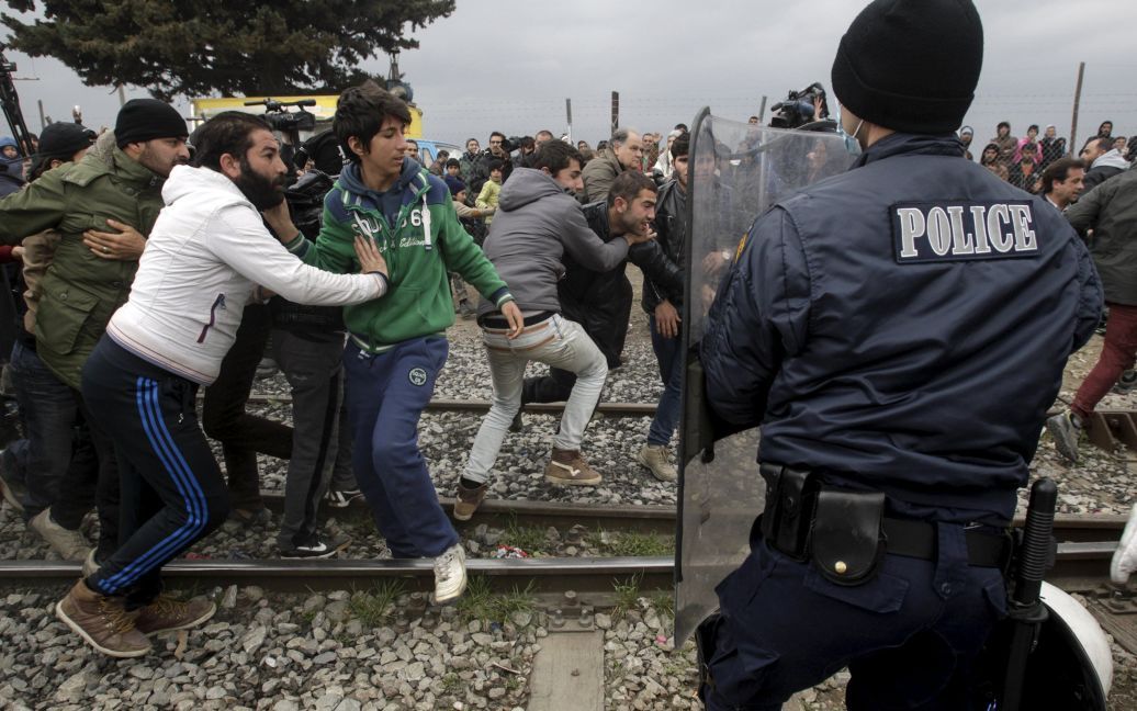 Люди разорвали колючую проволоку на заборе. / © Reuters