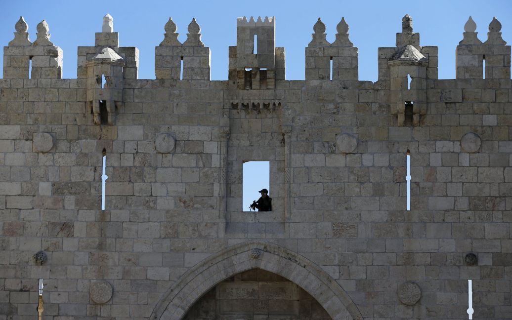 Израильский пограничный полицейский держит свое оружие при охране Дамасских ворот, главного входа в мусульманский квартал Старого города Иерусалима. / © Reuters
