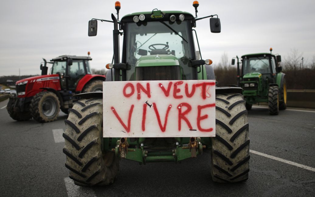 Французские фермеры блокируют кольцевую дорогу своими тракторами в Ренне в знак протеста против падения цен на их продукцию. На тракторе написано "Мы хотим жить". / © Reuters