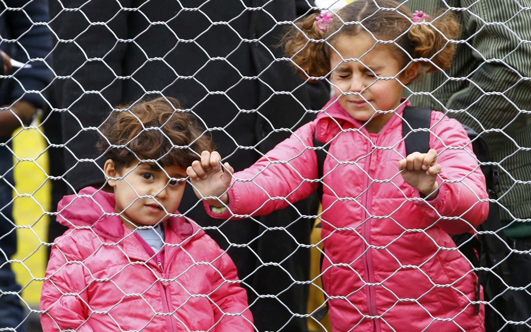 Дети мигрантов ждут, чтобы пересечь границу между Словенией и Австрией. / © Reuters