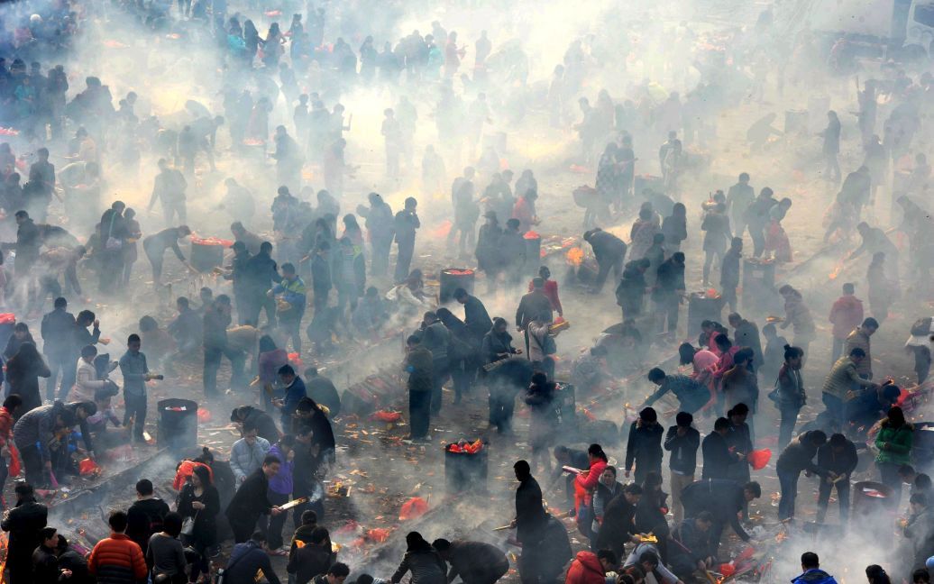 Люди поклоняются богу Фортуны на пятый день Китайского Нового года в Ухане, провинция Хубэй, Китай. / © Reuters