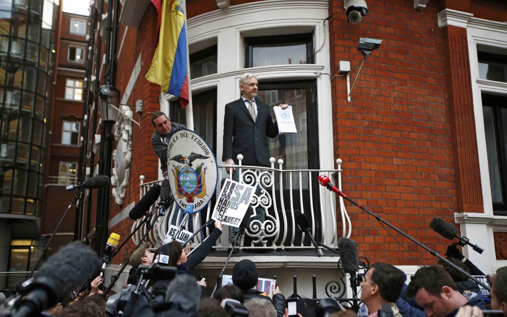 Основатель WikiLeaks Джулиан Ассанж показывает копию постановления ООН во время выступления с балкона эквадорского посольства в центре Лондона, Великобритания. Ассанжу должны разрешить выйти на свободу из посольства и присуждается компенсация за три с половиной года взаперти, говорится в постановлении комиссии ООН. / © Reuters