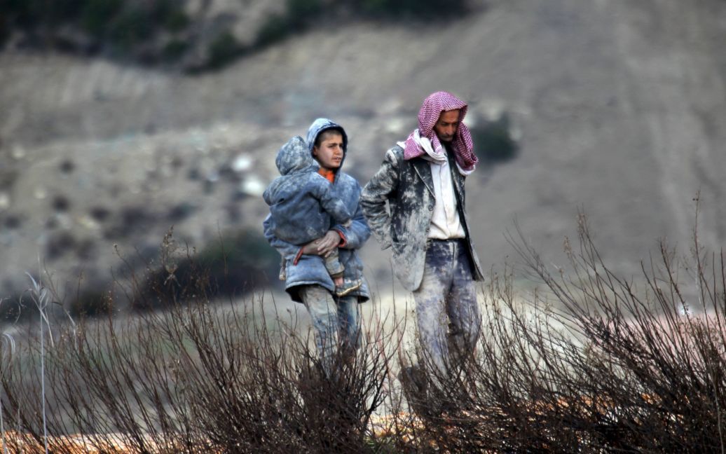 Беженцы, все в грязи, ждут разрешения пересечь границу в Турцию в городе Хирбет Аль-Джоз. / © Reuters