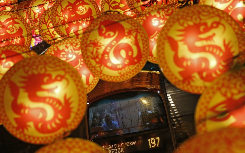 Автобус проезжает мимо уличных украшений с изображениями животных китайского зодиака накануне лунного Нового года в Сингапуре. В этом году празднование Китайского Нового года начнется в ночь на 8 февраля. / © Reuters