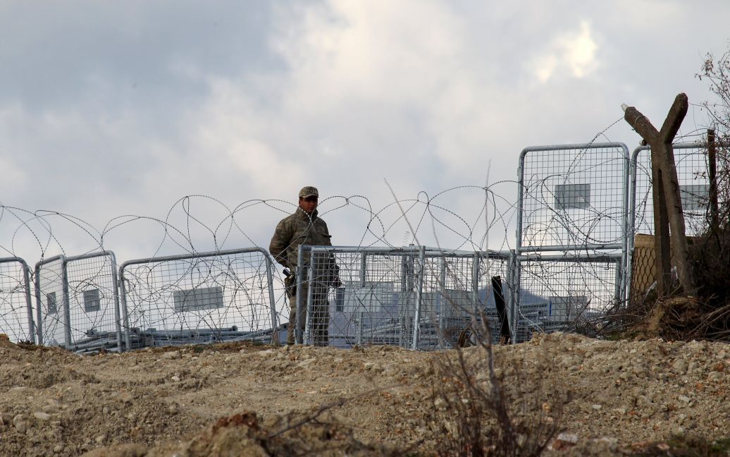 Турецкий солдат близ сирийского города Хирбет Аль-Джоз на турецко-сирийской границе, где вынужденные переселенцы ждут разрешения, чтобы пересечь границу с Турцией. / © Reuters
