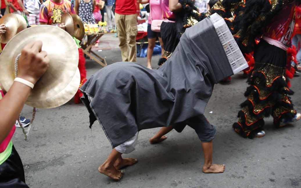 Манила, Филиппины. Мальчики идут в импровизированном косюмі дракона / © Reuters