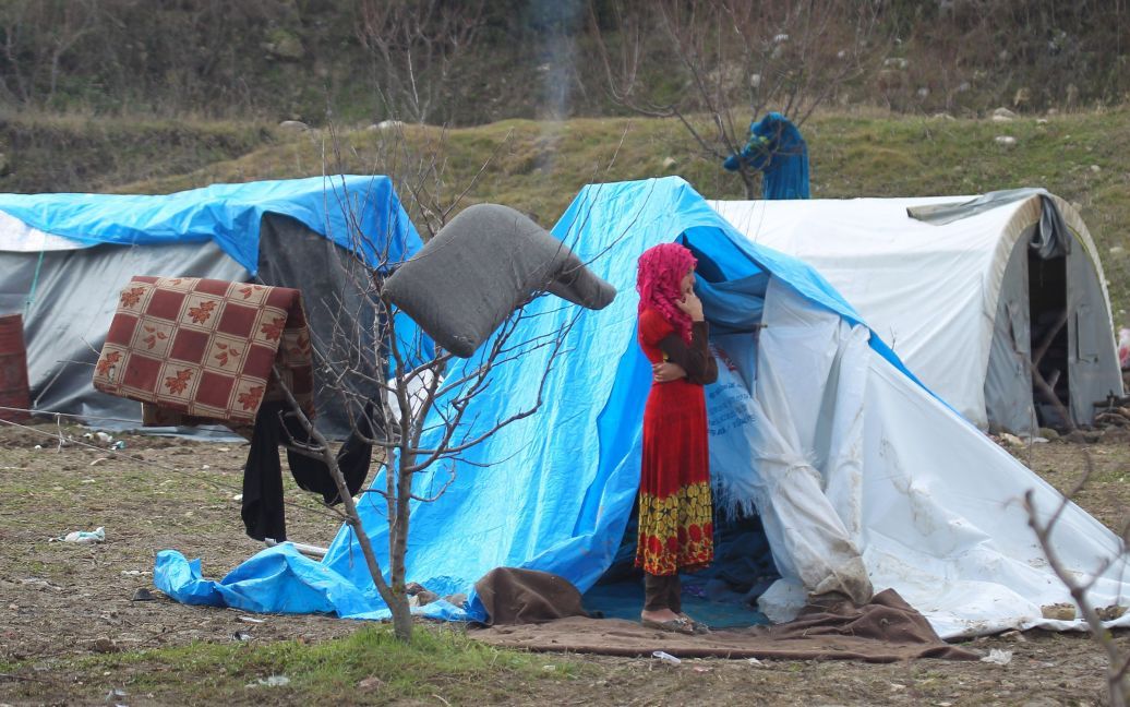 Девочка стоит возле палаток для вынужденных переселенцев в городе Хирбет Аль-Джоз. / © Reuters