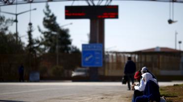 Люди сидят на тротуаре, на пересечении границы с Турцией, в юго-восточном городе Килис. / © Reuters