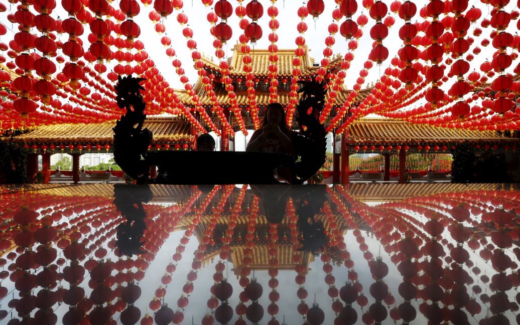 Жінка молиться під китайськими ліхтариками перед Китайським Новим роком у храмі в Куала-Лумпурі, Малайзія. / © Reuters