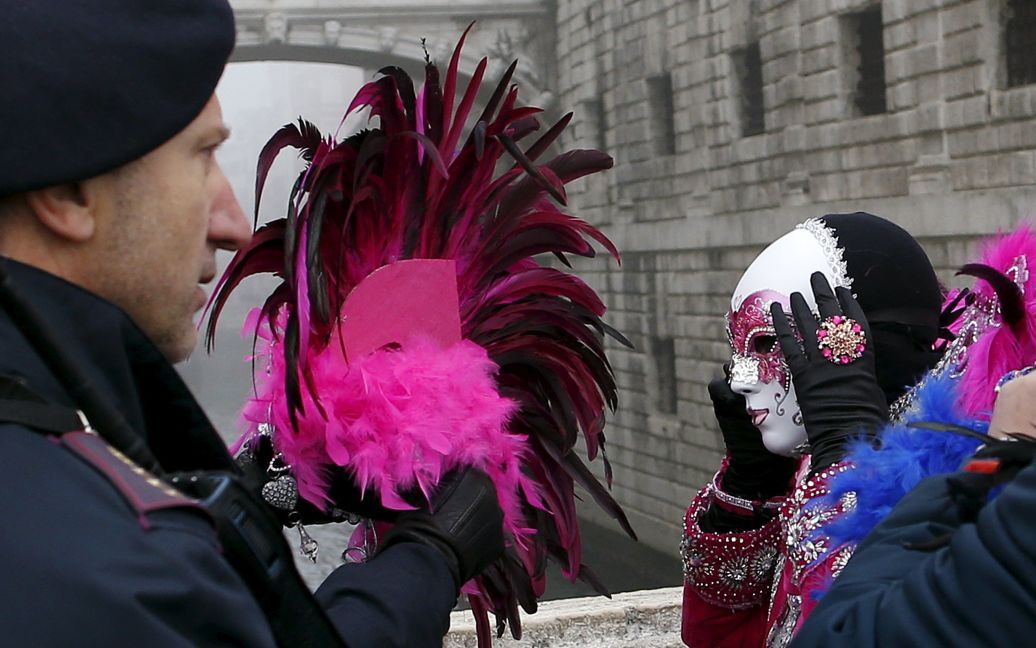 Итальянские полицейские проверяют людей в масках, которые прибывают на Венецианский карнавал. / © Reuters
