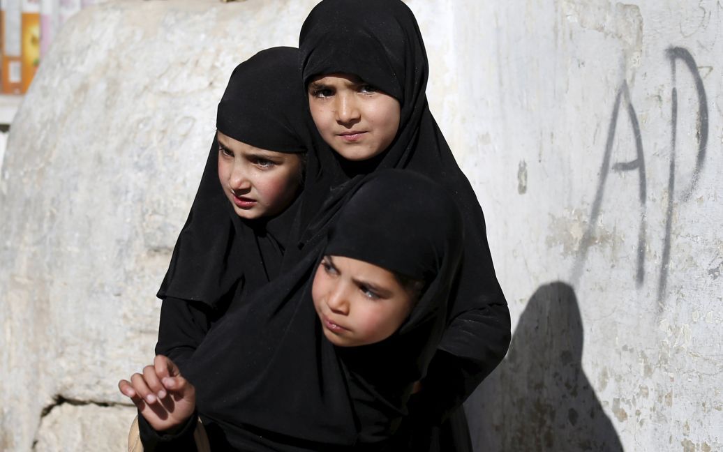Афганские девушки стоят на месте теракта в Кабуле, Афганистан. Десять человек были убиты и 20 ранены в результате теракта рядом с полицейским участком в оживленном районе западной части Кабула. / © Reuters