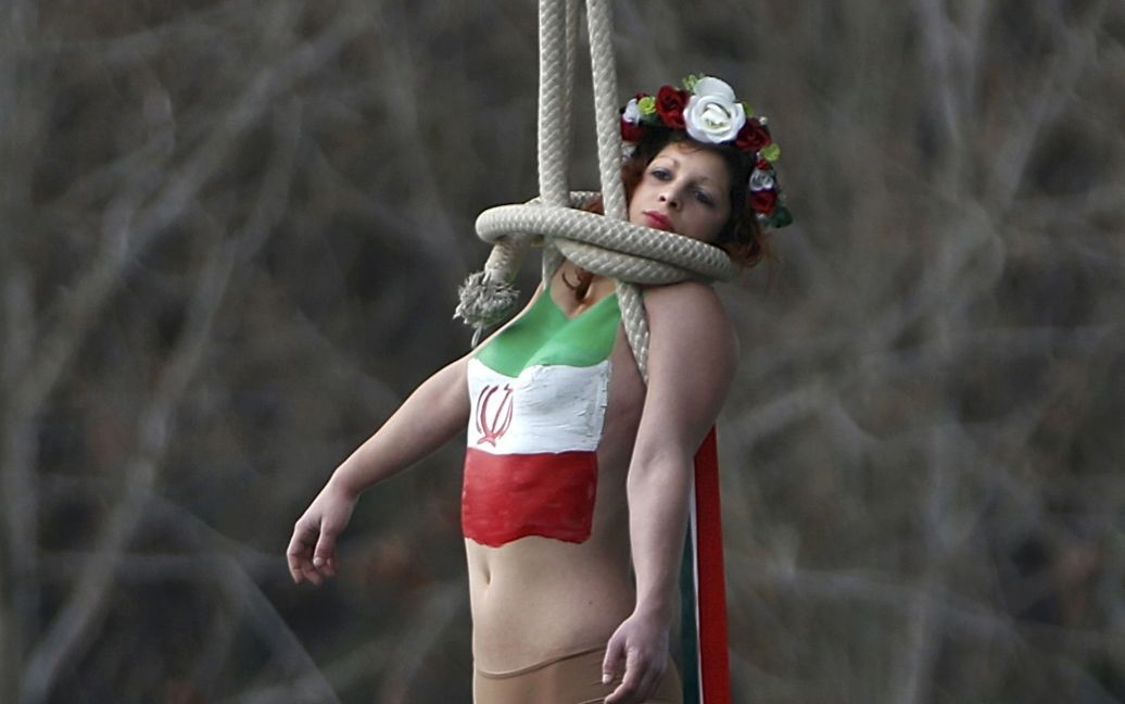 Активистка женского движения группе FEMEN висит на мосту во время акции протеста против визита во Францию ​​президента Ирана Роухани. Иран является лидером мира по количеству смертных приговоров - в этой стране они осуществляются через повешение. / © Reuters