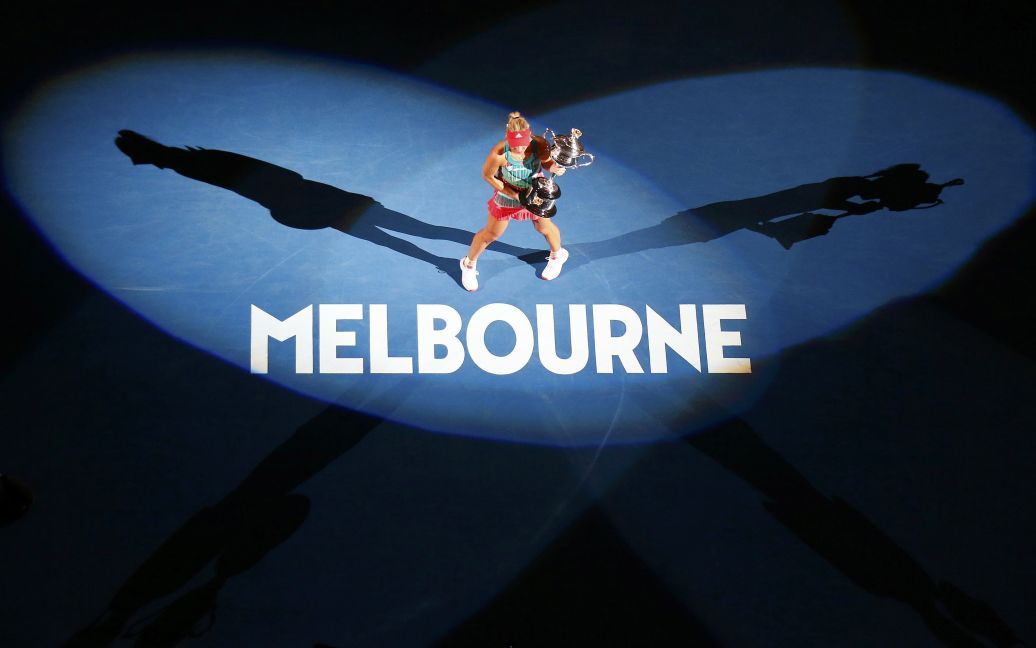 Немецкая теннисистка Кербер с трофеем празднует сенсационную победу над американкой Сереной Уильямс в финале Открытого чемпионата Австралии по теннису. / © Reuters