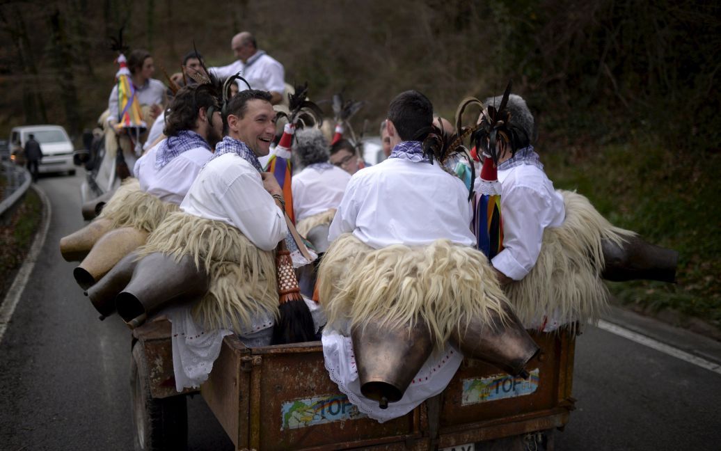 Танцоры едут на открытом прицепе на празднование карнавала в селе Итурен, Испания. Они будут исполнять ритуальный танец, чтобы отогнать злых духов и пробудить будущую весну. Наряду с танцорами местные жители одеваются в костюмы химер и чудовищ, чтобы преследовать и запугивать зрителей. / © Reuters