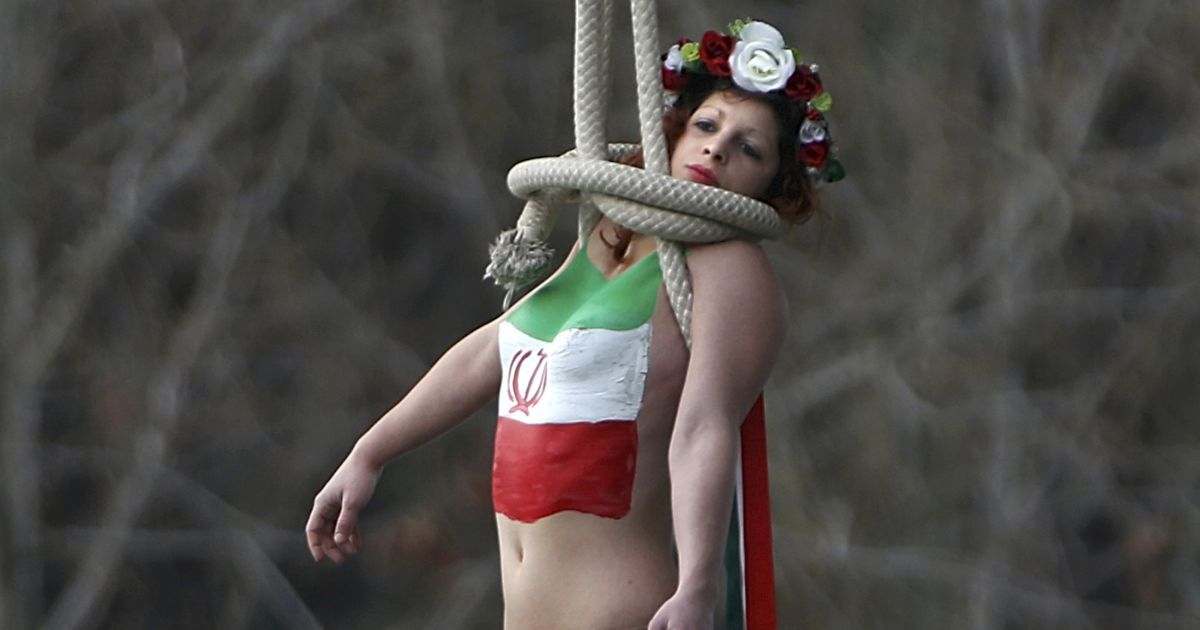 Активистка женского движения группе FEMEN висит на мосту во время акции протеста против визита во Францию ​​президента Ирана Роухани. Иран является лидером мира по количеству смертных приговоров - в этой стране они осуществляются через повешение. / © Reuters