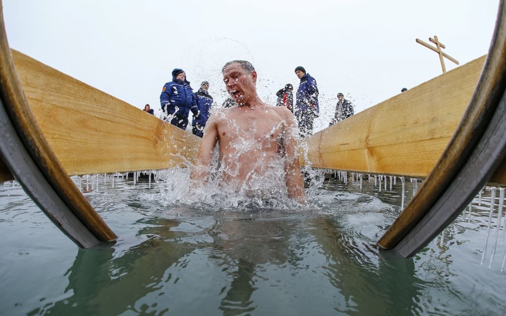 Чоловік занурюється у воду під час святкування Хрещення Господня на березі річки Велика Алматинка в Алмати, Казахстан. / © Reuters