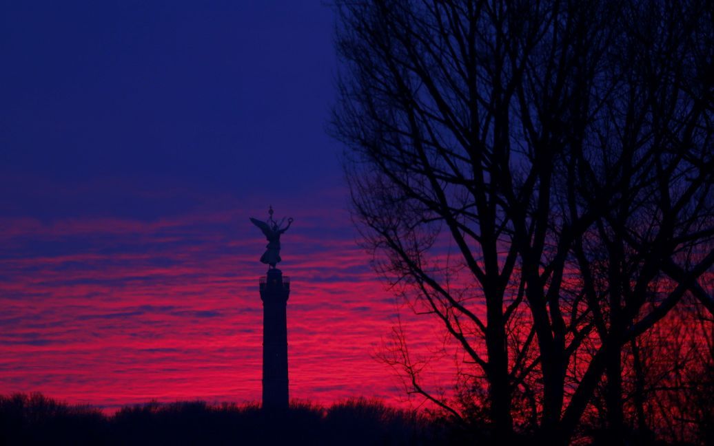 Фотограф сфотографировал памятник &laquo;Золотая Эльза&raquo; в верхней части Колонны Победы в Берлине на фоне заката. / © Reuters