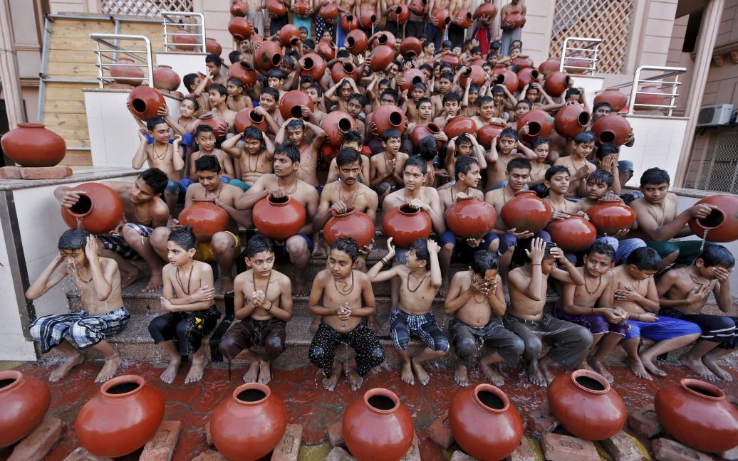 Ученики держат глиняные кувшины, наполненные водой, во время церемонии омовения в Ахмедабаде, Индия. Церемония проводится во время индуистского религиозного праздника Магха, который длится в течение месяца, когда тысячи верующих погружаются в водах в месте слияния рек Ганга, Ямуна и Сарасвати. / © Reuters