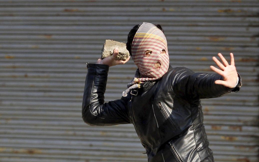 Митингующий-мусульманин бросает камень в сторону индийской полиции во время акции протеста в Сринагаре, Кашмир. Столкновения между полицией и индийскими мусульманами начались после митинга, организованного сепаратистским Фронтом освобождения Джамму и Кашмира. / © Reuters