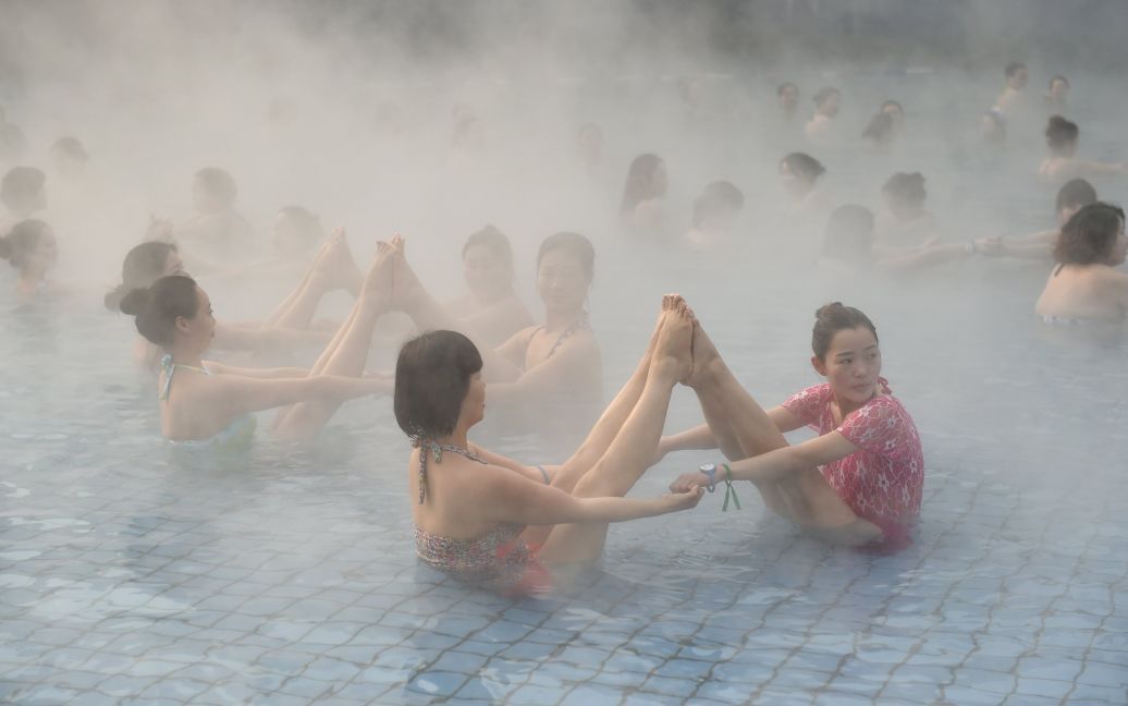 Женщины занимаются йогой в горячем источнике в городе Лоян, провинция Хэнань, Китай. Около ста женщин занимались йогой, в то время как на улице была температура в минус четыре градуса по Цельсию. / © Reuters