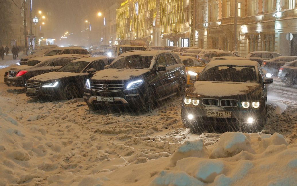 Автомобили паркуются возле кучи снега в центре Москвы, Россия. / © Reuters
