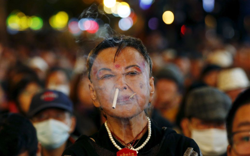 Сторонник Новой партии власти Тайваня курит на митинге перед выборами в Тайбэе, Тайвань. / © Reuters