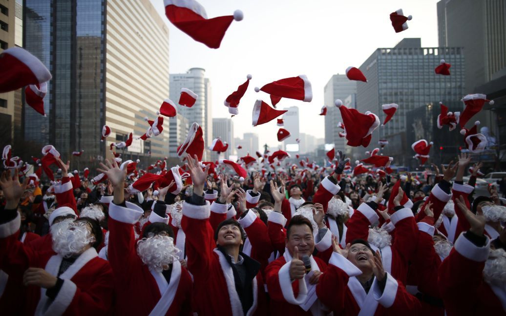 Сотні Санта Клаусів підкидають шапки в повітря під час благодійної акції в центрі Сеула / © Reuters