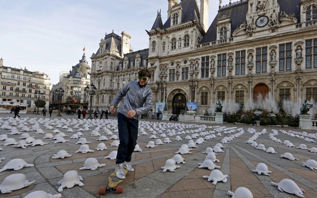 Молодик їде на скейтборді через інсталяцію французького художника Рашида Хімона. Інсталяція, встановлена перед мерією Парижу, зображує скульптуру у вигляді тисяч черепах. / © Reuters