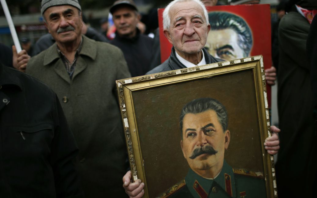 Чоловік несе портрет радянського лідера Йосипа Сталіна, йдучи під час мітингу з нагоди річниці дня народження Сталіна в його рідному місті Горі, Грузія. / © Reuters