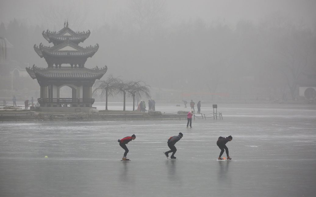 Люди катаються на озері в парку у туманним день в Пекіні, Китай. / © Reuters